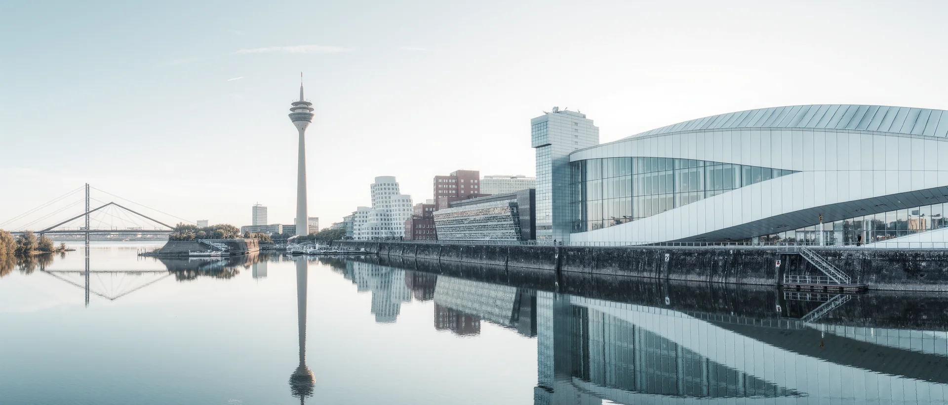 Düsseldorfer Medienhafen bei Tageslicht mit Rheinturm und Spiegelung im Wasser